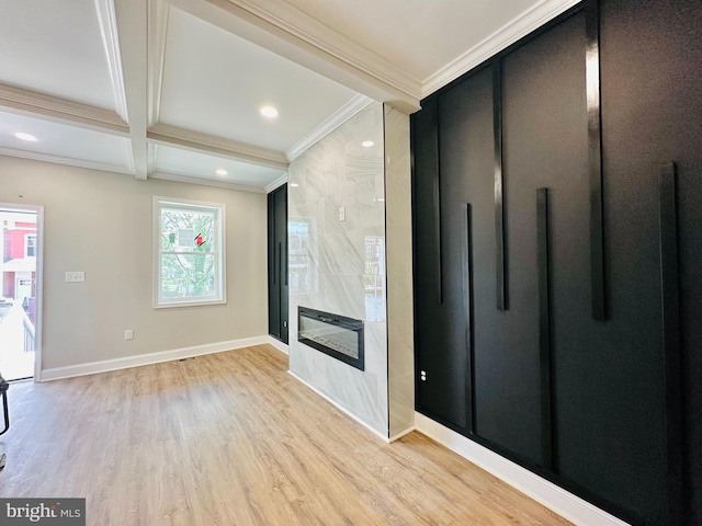 unfurnished living room featuring light wood finished floors, baseboards, ornamental molding, beam ceiling, and a high end fireplace