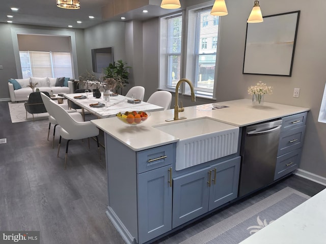 kitchen featuring pendant lighting, dark hardwood / wood-style floors, dishwasher, sink, and kitchen peninsula