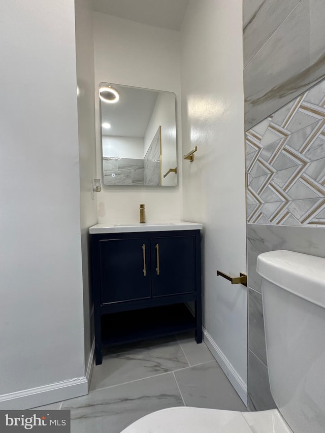 bathroom with toilet, vanity, and tile patterned flooring