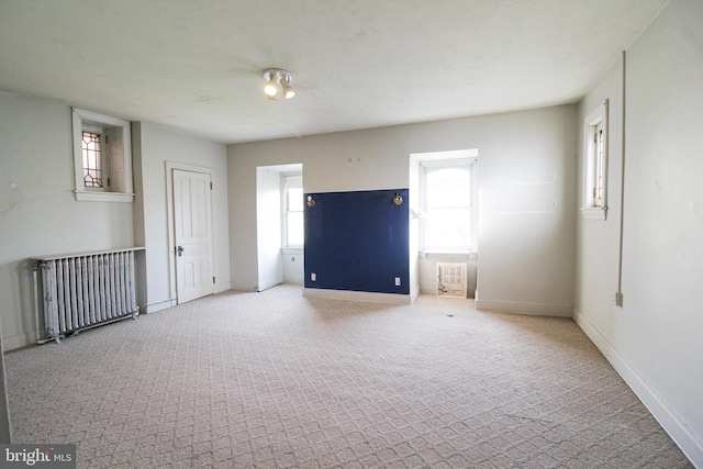 empty room with radiator heating unit and carpet