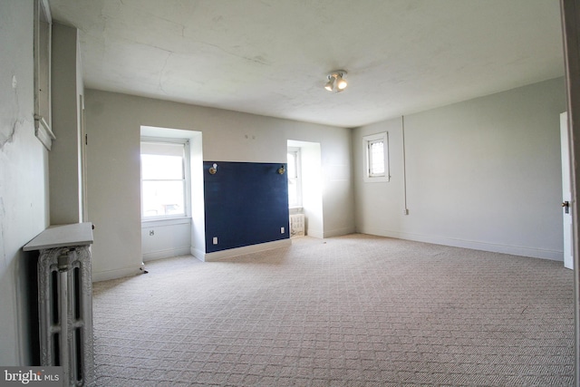 unfurnished living room with light colored carpet and a healthy amount of sunlight