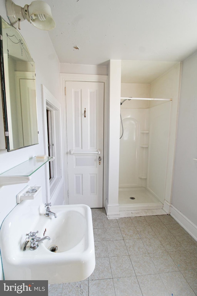 bathroom with tile patterned flooring, sink, and a shower