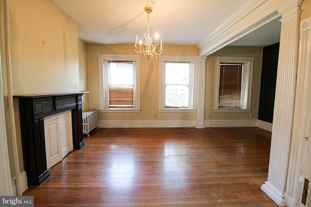 unfurnished dining area with dark hardwood / wood-style flooring, radiator, and an inviting chandelier