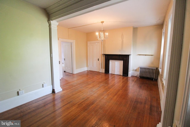 unfurnished living room featuring hardwood / wood-style flooring, radiator, an inviting chandelier, and ornate columns