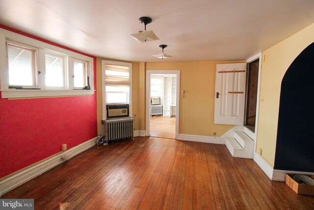 interior space with dark wood-type flooring and radiator heating unit