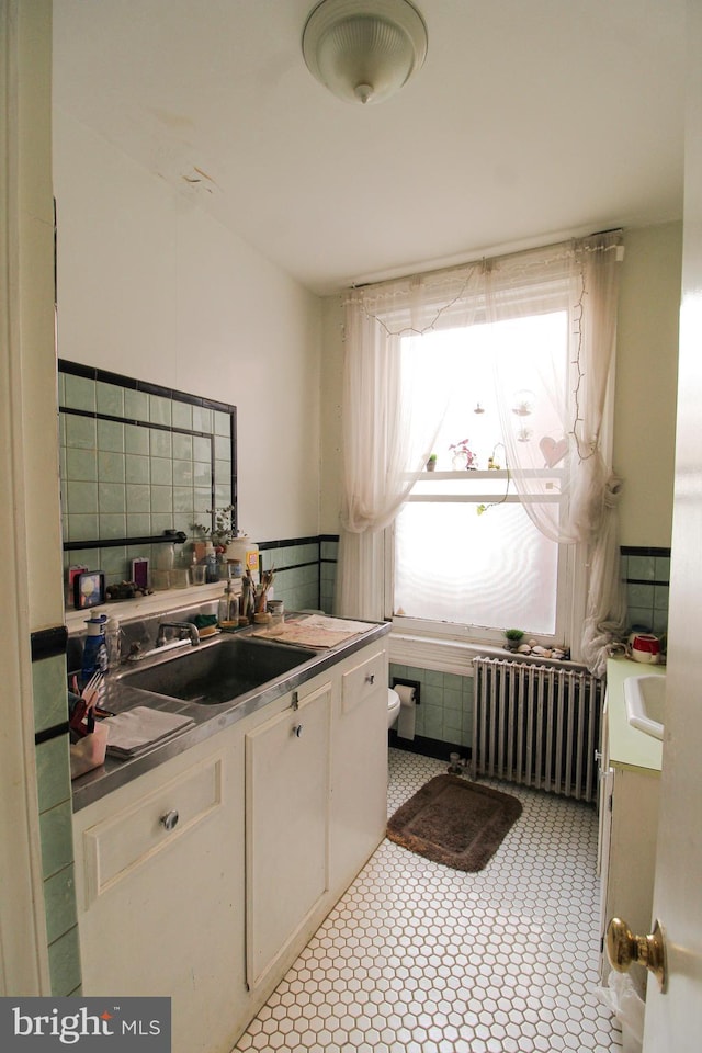 laundry room featuring sink and radiator heating unit