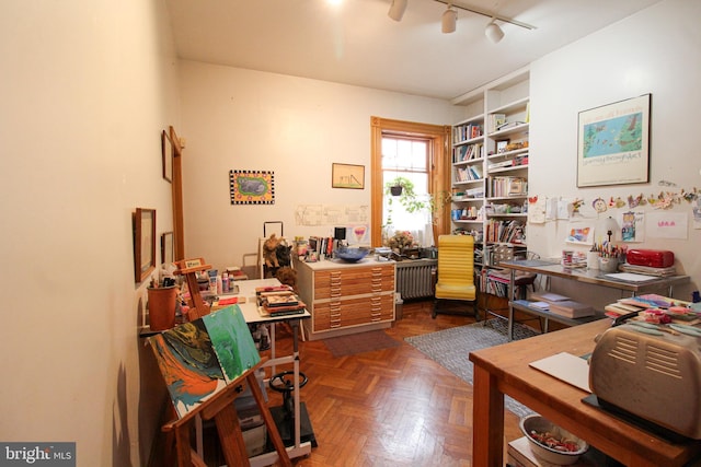 office featuring radiator, dark parquet flooring, and rail lighting