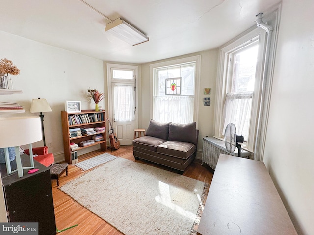 living area with wood-type flooring and radiator heating unit