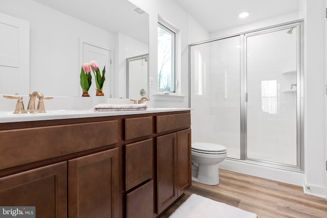 bathroom with toilet, wood-type flooring, an enclosed shower, and vanity