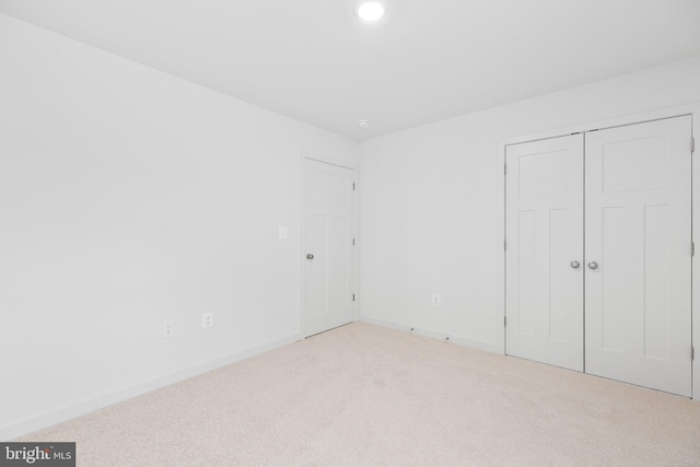 unfurnished bedroom with a closet, carpet flooring, and baseboards