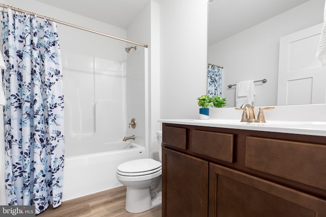 full bathroom featuring hardwood / wood-style floors, toilet, shower / tub combo with curtain, and vanity