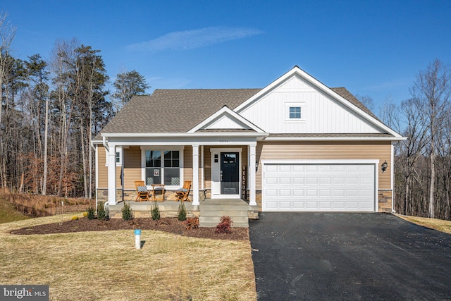 view of front of home featuring stone siding, a porch, board and batten siding, and aphalt driveway