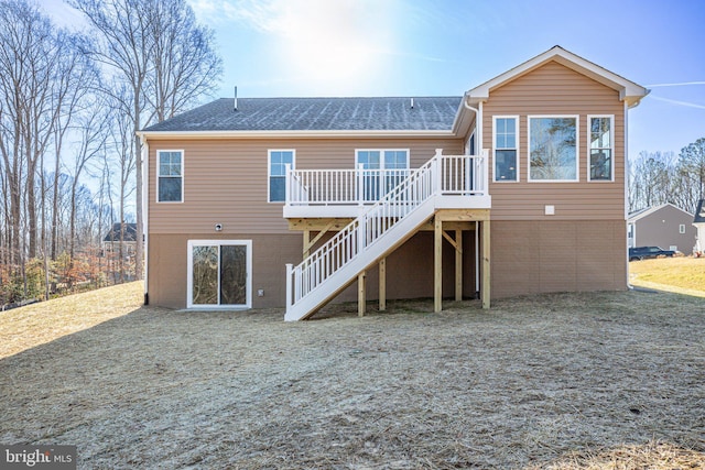 back of house with roof with shingles, stairway, a deck, and brick siding