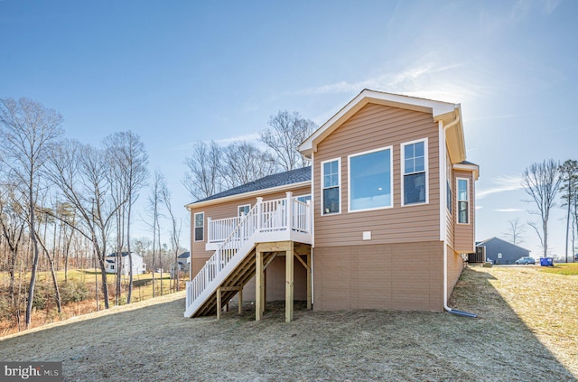 view of front facade with a deck, brick siding, stairway, and central air condition unit