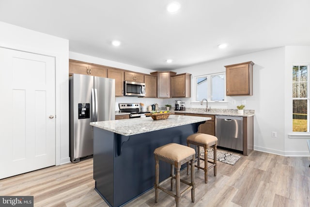 kitchen featuring plenty of natural light, stainless steel appliances, light wood-type flooring, and a kitchen island