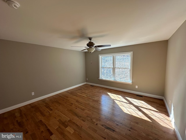 unfurnished room with light wood finished floors, ceiling fan, and baseboards