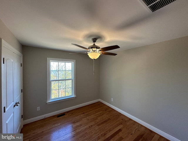 unfurnished bedroom with a ceiling fan, visible vents, baseboards, and wood finished floors