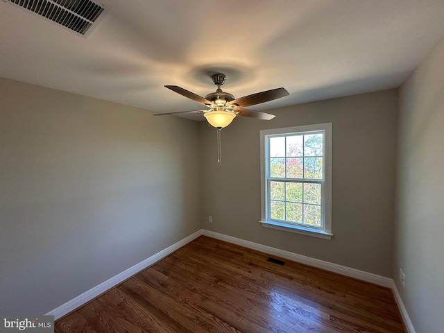 empty room with visible vents, ceiling fan, baseboards, and wood finished floors