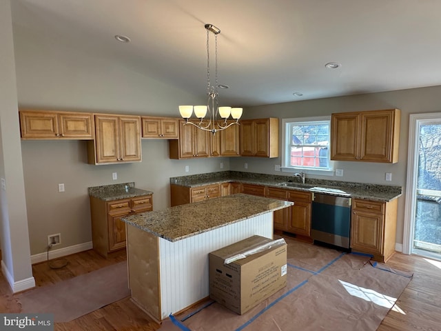 kitchen featuring hanging light fixtures, stone countertops, a kitchen island, a sink, and dishwasher