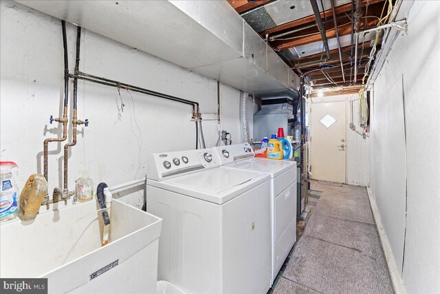 clothes washing area with washer and clothes dryer and sink