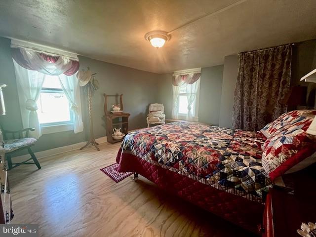 bedroom featuring wood finished floors and baseboards