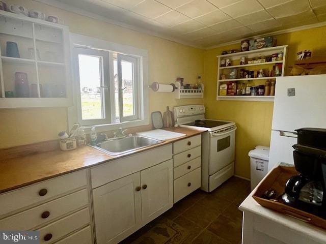 kitchen featuring white appliances, a sink, white cabinets, light countertops, and ornamental molding