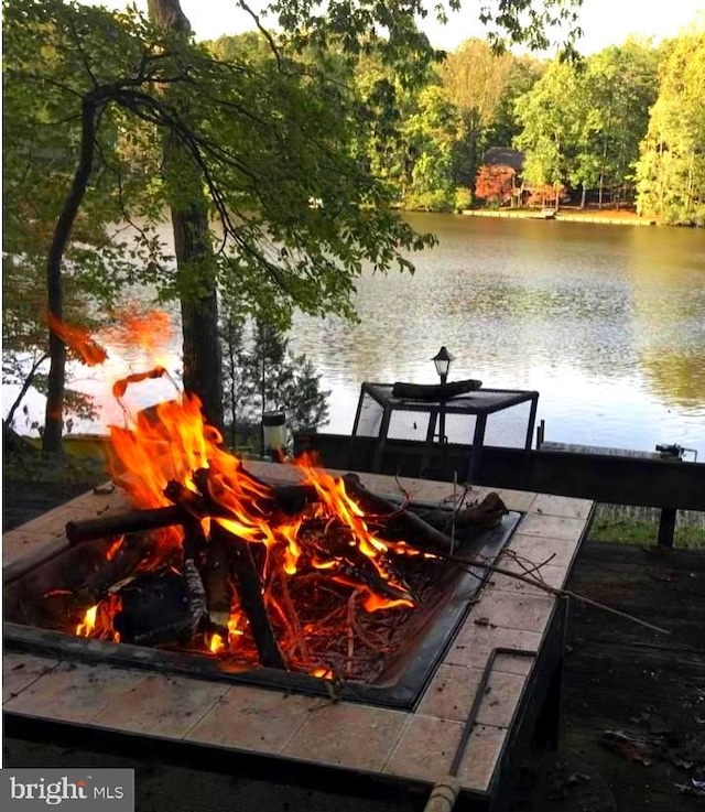 dock area featuring an outdoor fire pit and a water view