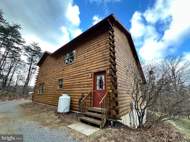 view of property exterior featuring entry steps and log siding