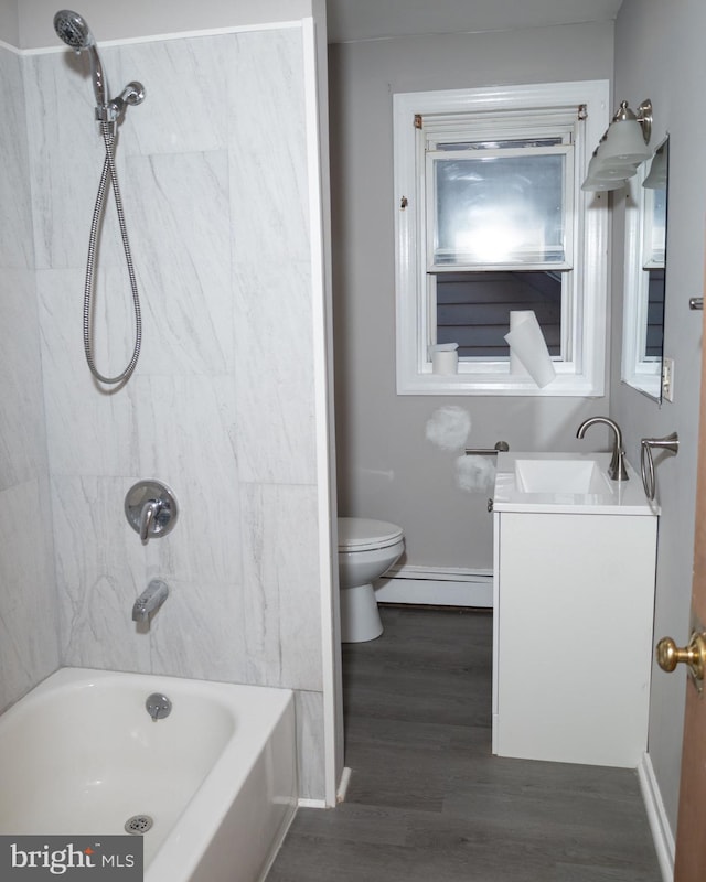 full bathroom with vanity, a baseboard radiator, toilet, tiled shower / bath, and hardwood / wood-style flooring