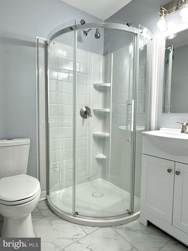 full bath featuring vanity, toilet, marble finish floor, and a stall shower