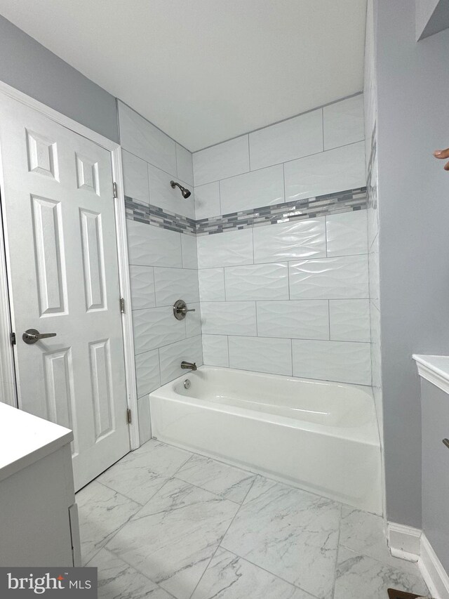 bathroom with marble finish floor, vanity, and bathing tub / shower combination