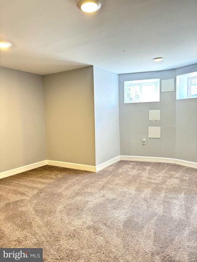 below grade area featuring carpet flooring and baseboards