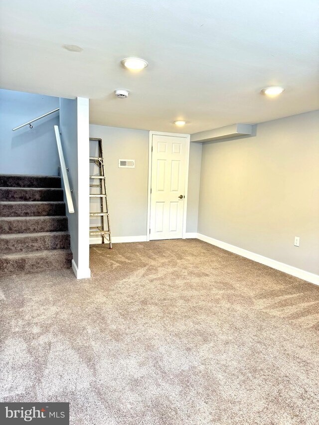 finished basement featuring stairway, carpet flooring, baseboards, and visible vents