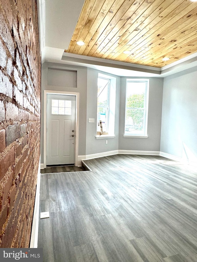 entryway featuring wood ceiling, a raised ceiling, and baseboards