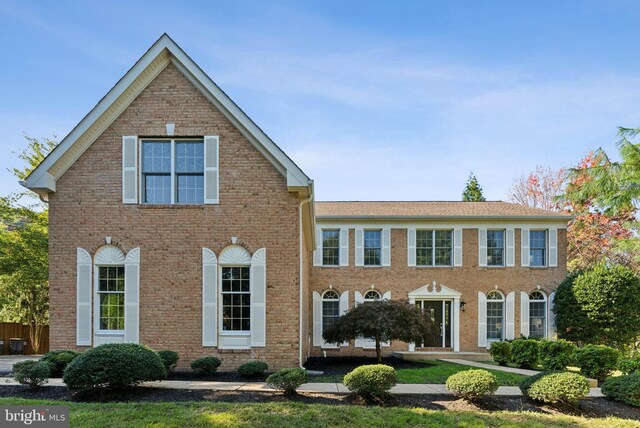 colonial home with a garage and a front lawn