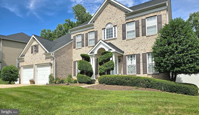 view of front of property with a garage, a front yard, concrete driveway, and brick siding