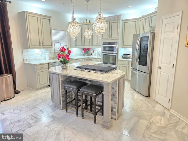 kitchen featuring light stone counters, a center island, a kitchen breakfast bar, stainless steel appliances, and decorative backsplash