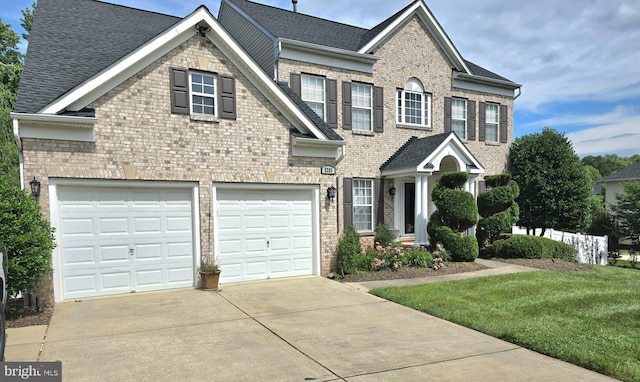 view of front facade featuring concrete driveway, a garage, brick siding, and roof with shingles