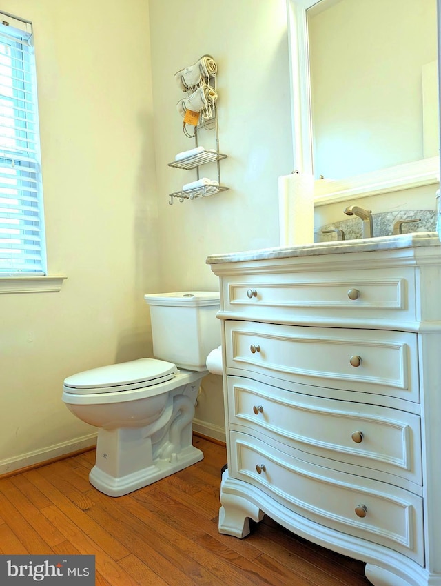 bathroom with hardwood / wood-style flooring, vanity, and toilet