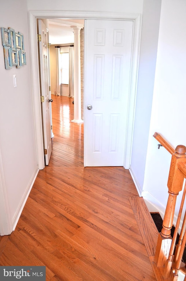 hall with wood-type flooring and ornate columns