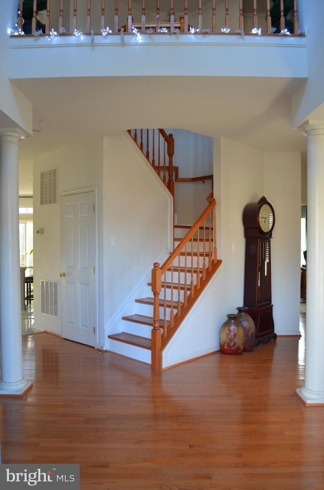 stairway featuring hardwood / wood-style flooring and a towering ceiling