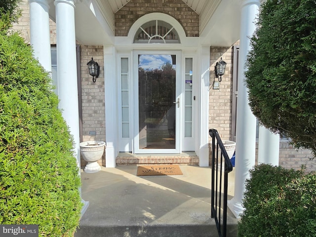 doorway to property featuring brick siding