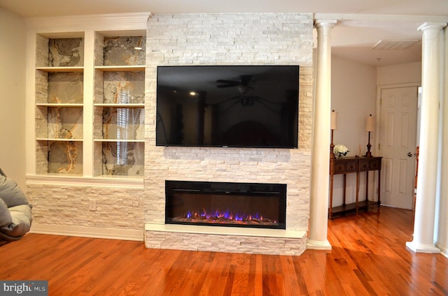 living room with a fireplace, hardwood / wood-style floors, and ornate columns