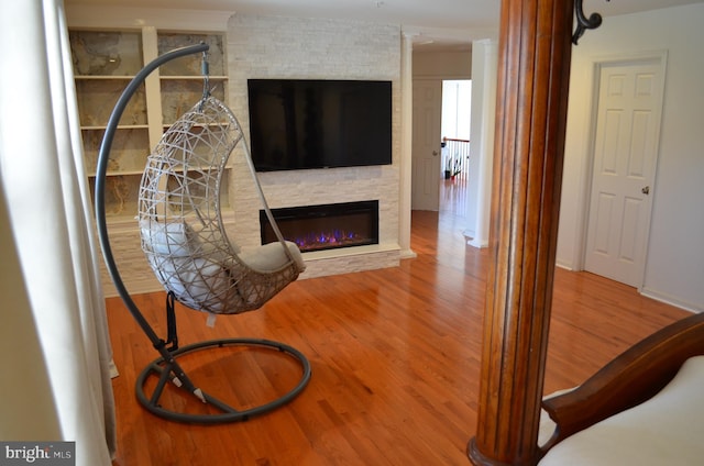 living room with hardwood / wood-style flooring and a large fireplace