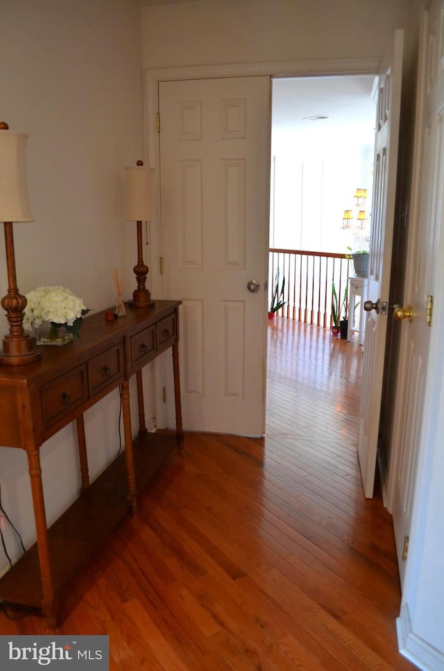 corridor with hardwood / wood-style flooring