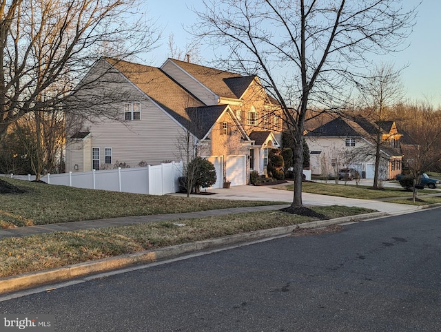 view of side of property featuring a garage and a lawn