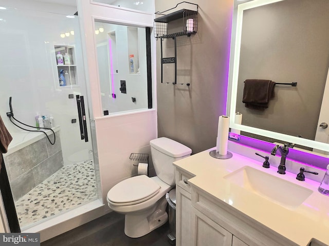 full bathroom featuring a shower stall, toilet, and vanity