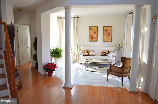 sitting room with light hardwood / wood-style floors and ornate columns