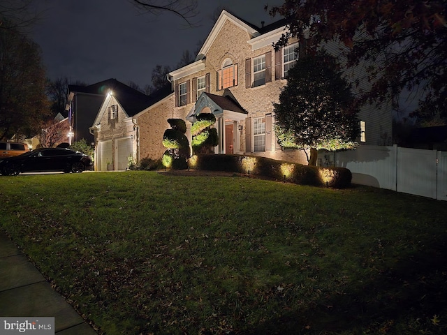 property exterior at twilight with a garage and a lawn