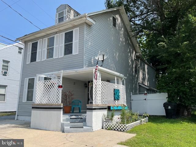 view of front of house with a front yard and fence